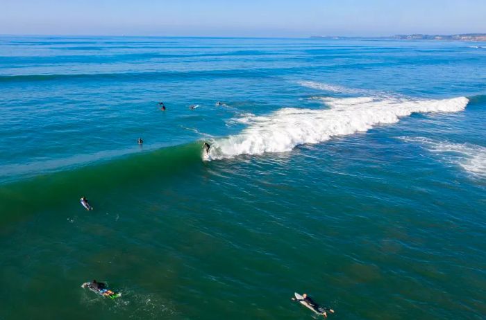 Surfers take advantage of the final day of summer with a surf session at a beach on Mornington Peninsula in Victoria, Australia, captured from above.