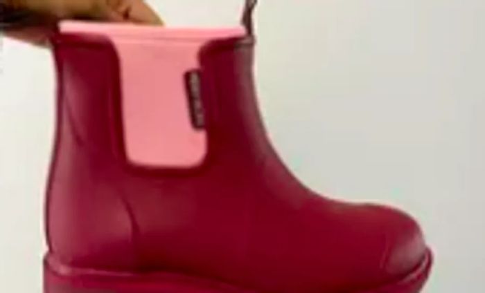 A hand gripping a Merry People Bobbi Rain Boot