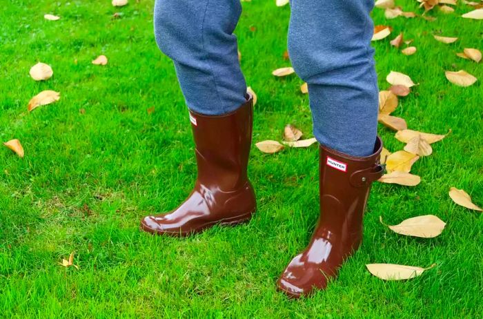 A person is seen wearing Hunter Women's Original Short Rain Boots outside