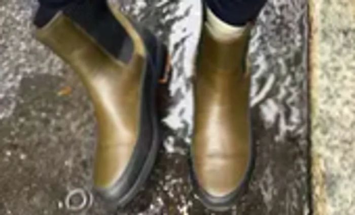 A person stands in water while wearing the Forsake Sofia Chelsea Women's Waterproof Boots