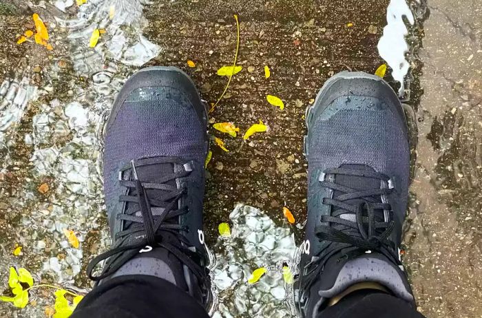 Close-up view of On Cloudrock 2 boots worn by a person