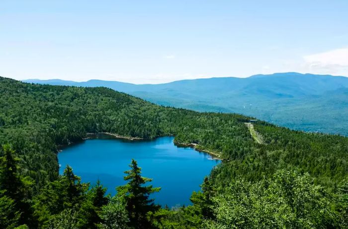 A serene lake beneath a clear blue sky in New Hampshire's White Mountains