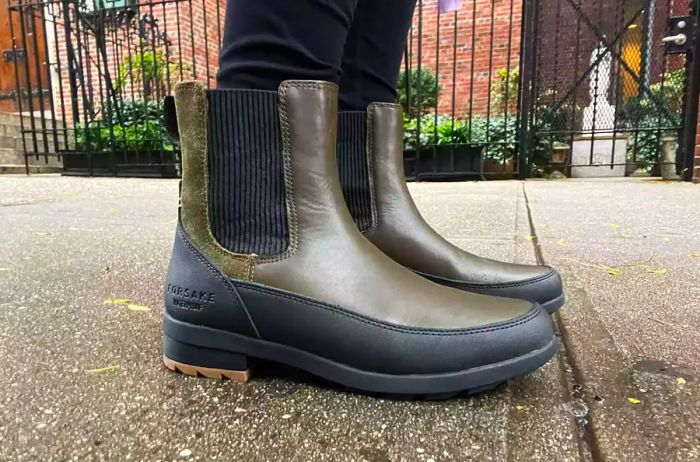 A person sporting Forsake Sofia Chelsea Women's Waterproof Outdoor Boots while walking on a sidewalk