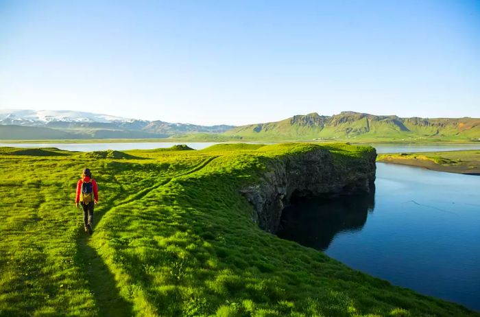 A hiker exploring a serene lagoon in Iceland