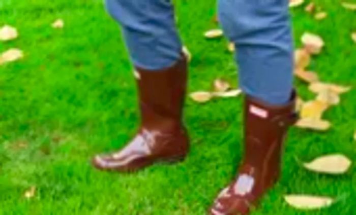 A person is seen wearing Hunter Women's Original Short Rain Boots outside