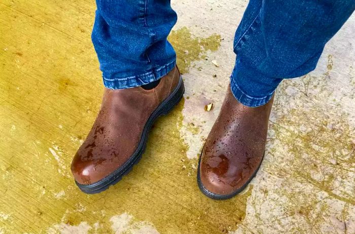 A person stands in water, showcasing the Blundstone Men’s Thermal Waterproof Chelsea Boots