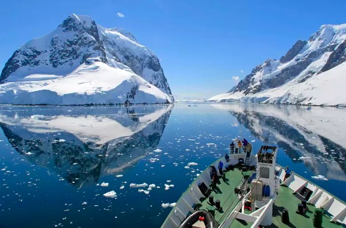 A small cruise ship navigates the stunning Lemaire Channel in Antarctica.