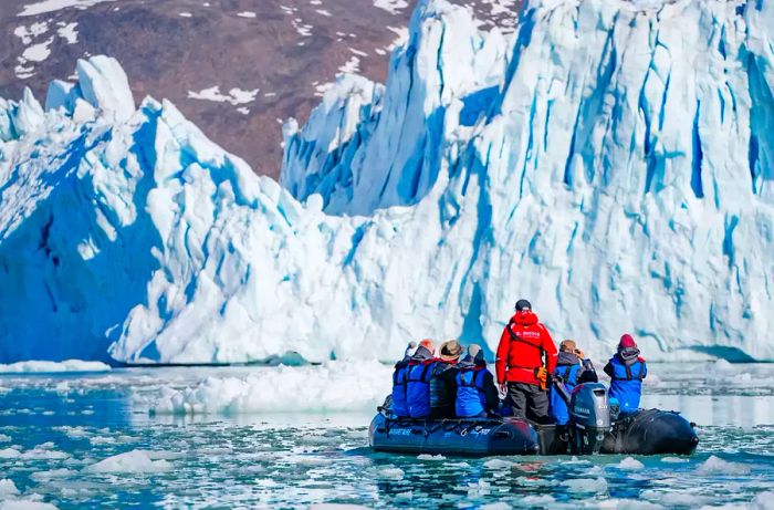 Zodiac with guests approaching the glacier face, Monacobreen in Spitsbergen, Svalbard