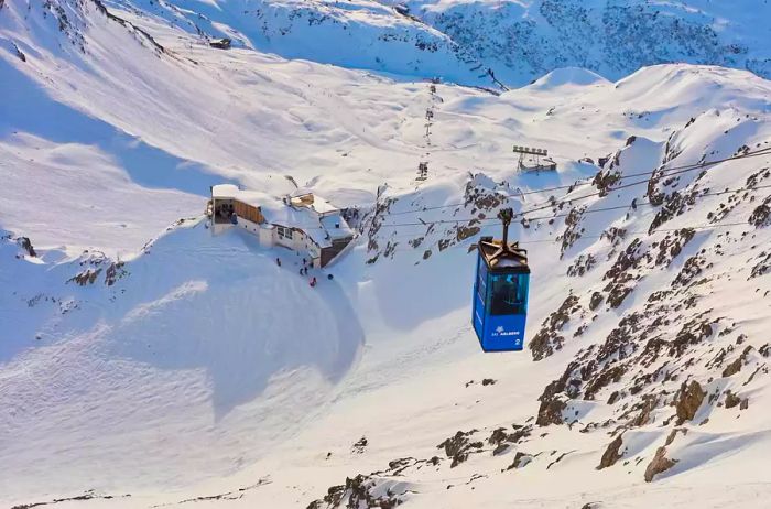 An alpine skier and a cable car ascend to the Valluga on January 8, 2014, in St. Anton, Tyrol, Austria.