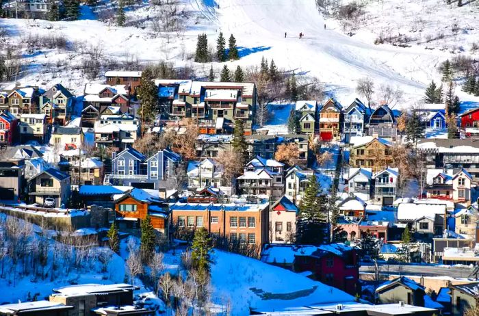 Winter vacation homes nestled on the hillside in downtown Park City's ski area, set against the stunning Wasatch Mountains near Salt Lake City, Utah.