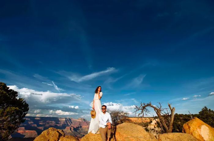 Newlyweds perched on a rock overlooking the Grand Canyon.