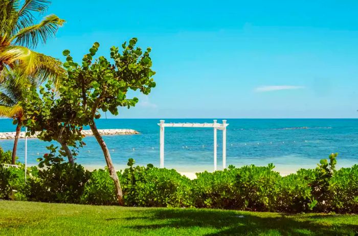 Lush greenery and a white awning on a beach in Jamaica