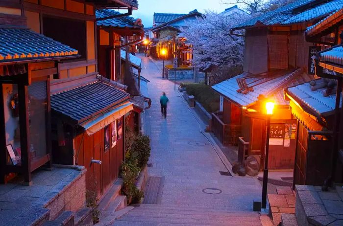 A silhouette meandering through the streets of Kyoto on a winter evening