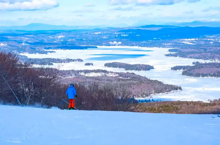 A skier enjoys the view from the summit of Mount Sunapee