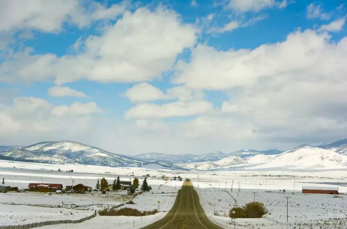 Long road winding through a snow-covered desert and mountains