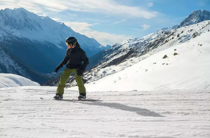 A young man snowboarding down a slope.