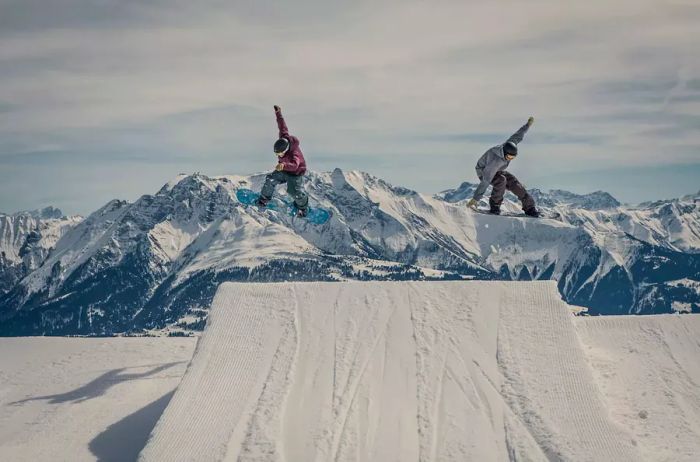 A snowboarder catching air synchronously in Laax, Switzerland.