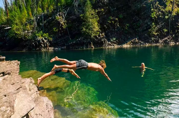 Two children leaping into a lake.