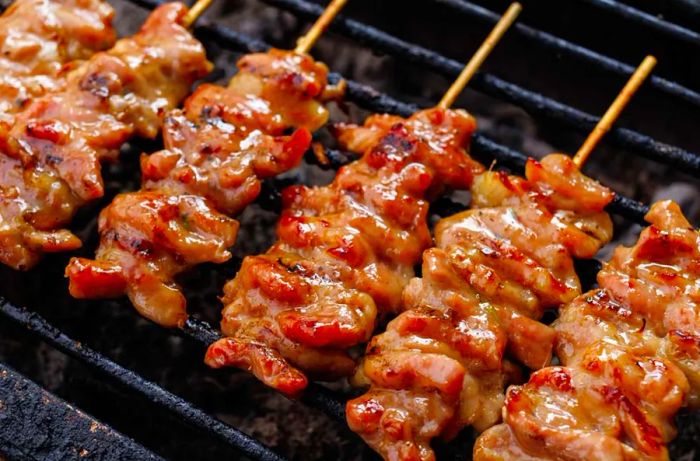 Delicious grilled pork skewers sizzling on the grill.