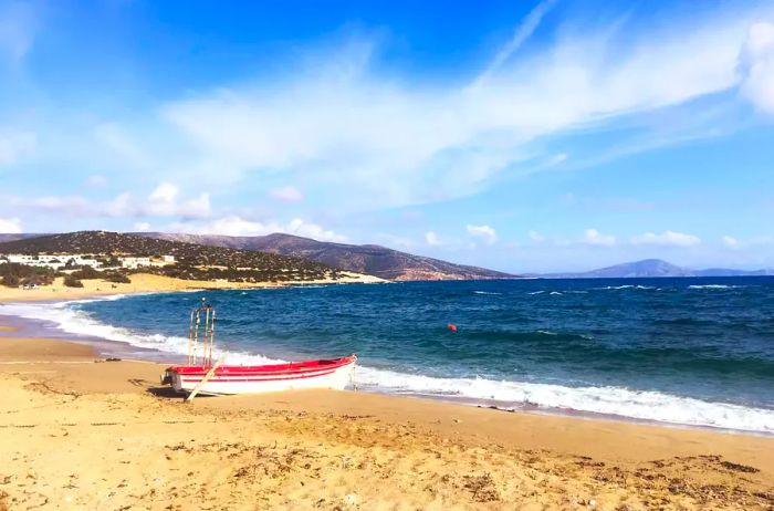 A small rowboat rests on the beach in Naxos