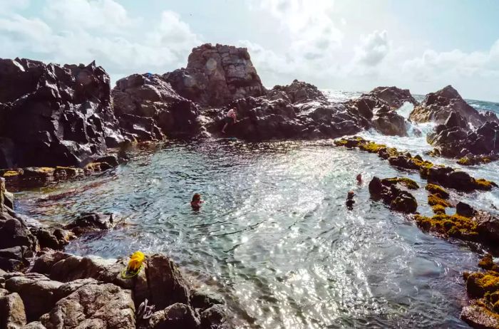 People enjoying a swim in a Natural Pool in Aruba