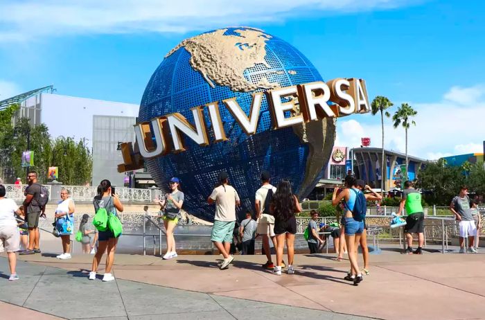 Tourists capture moments at the globe outside Universal Studios' entrance.