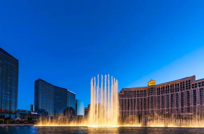 The Bellagio Hotel Casino in Las Vegas, renowned for its iconic fountain show, illuminated at night with fountains dancing in Las Vegas, Nevada.