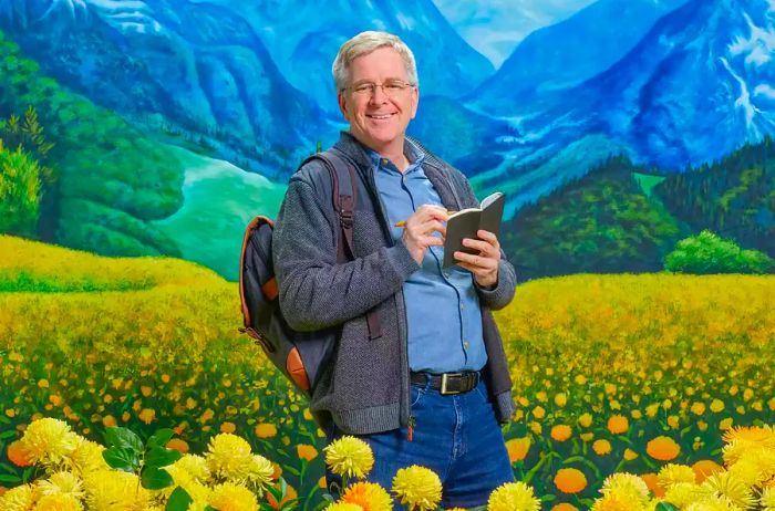 Rick Steves posing in a field of artificial flowers