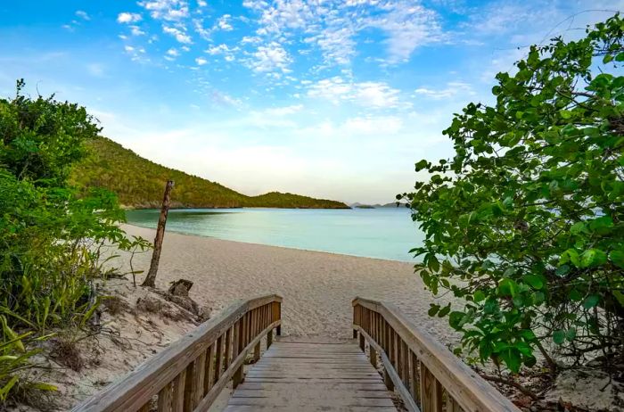 A stunning sunrise illuminates the iconic Trunk Bay on the tropical Caribbean island of St. John in the U.S. Virgin Islands.