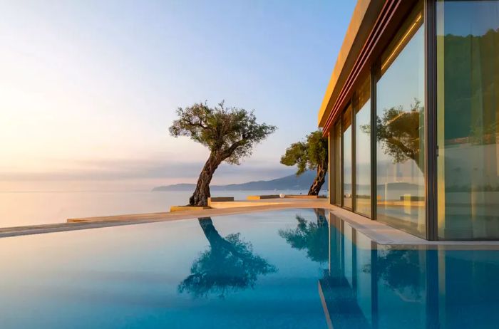 Pool surrounded by trees at Domes Miramare Corfu