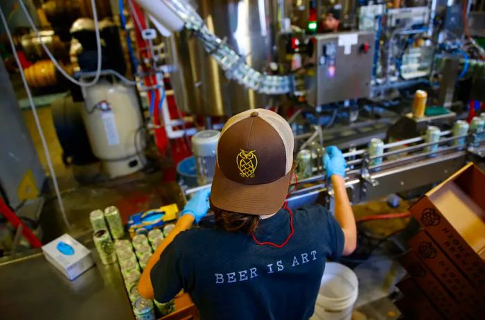 Matt Groff, the cellarman, operates the canning line at Night Shift Brewing.