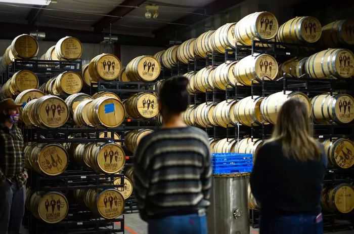 Two individuals observing barrels at Corsair Distillery