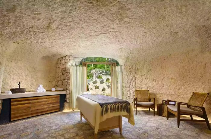 A spa room resembling a cave, featuring stone walls, floors, and ceiling.