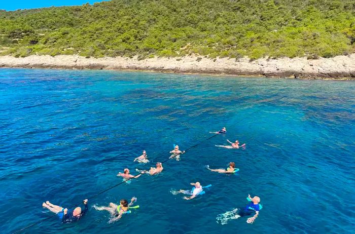 A group enjoying a swim in the crystal-clear waters of the Adriatic Sea in Croatia.