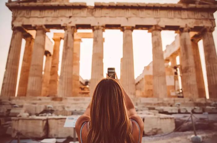 A woman captures a photo of the Pantheon