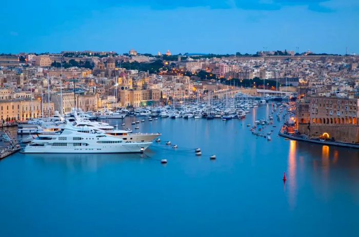 Dusk settles over boats moored in the marina of Valletta, Malta.