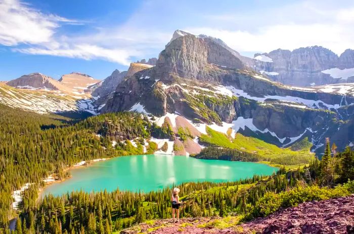 A young woman enjoys a hike through Glacier National Park in Montana on a picturesque summer day.