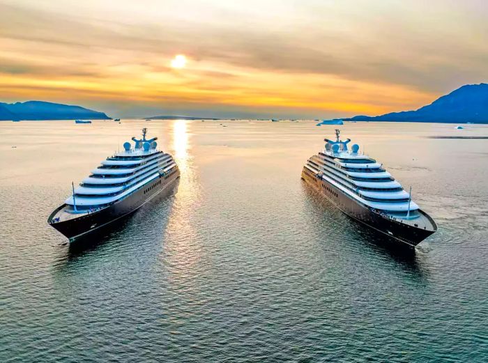 Aerial view of two Scenic Eclipse ships with the sunset in the background, facing the camera.