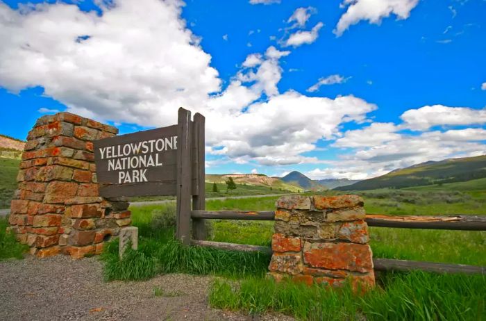 The entrance gate to Yellowstone National Park in the United States welcomes visitors to the oldest national park in the country, which stretches across Wyoming, Montana, and Idaho. It boasts numerous iconic landmarks, including the world-renowned Old Faithful geyser, attracting millions of visitors each year.