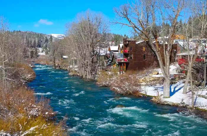 A blue river flows past charming historic houses in Truckee