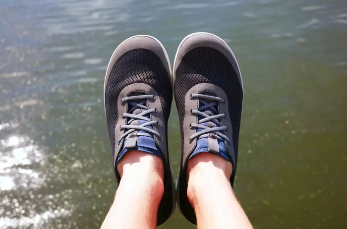 A close-up view of a person's feet in OLUKAI Men's Moku Pae Water Shoes.