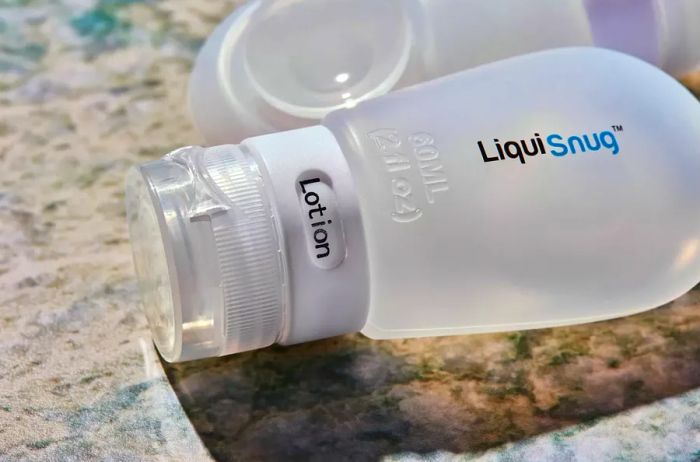 Close-up of Liquisnugs Premium Leak-Proof Silicone Travel Bottles on a granite countertop