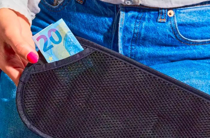 A person puts cash into the Raytix Money Belt