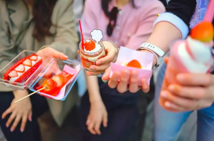 A group of Gen Z tourists enjoying traditional red desserts and pastries in Dotonbori, Japan.