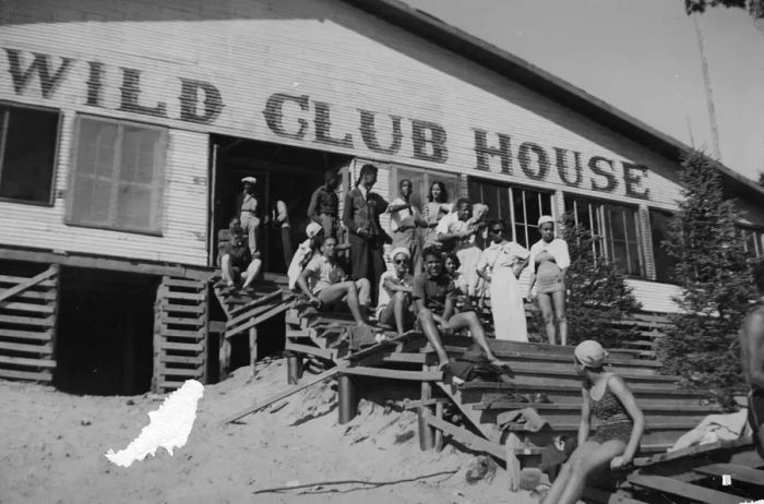 A portrait of unknown individuals on the wooden steps of the Idlewild Club House in Idlewild, Michigan, taken in September 1938.