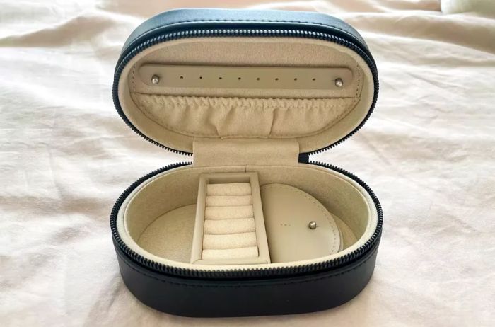 Monos Travel Jewelry Case displayed open on a bed