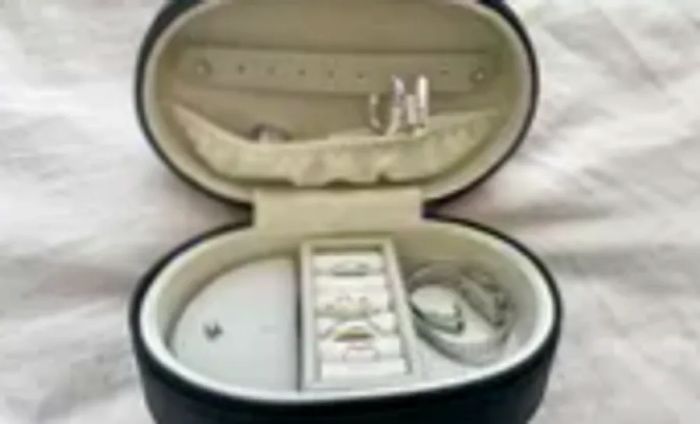 Monos Travel Jewelry Case shown open on a bed