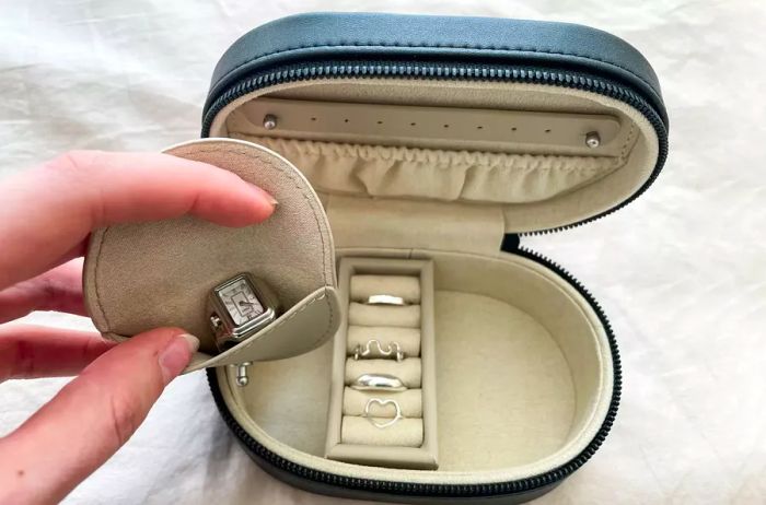 Monos Travel Jewelry Case opened and displayed on a bed