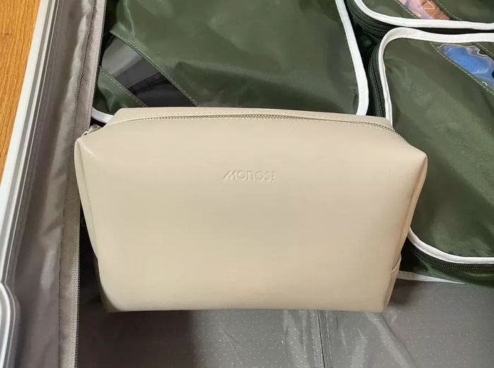 Monos Large Toiletry Case nestled in a suitcase