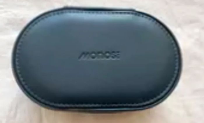 Monos Travel Jewelry Case resting closed on a bed